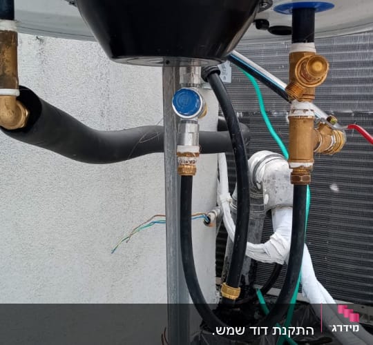 חיבורים וצינורות מתחת לדוד שמש על גג